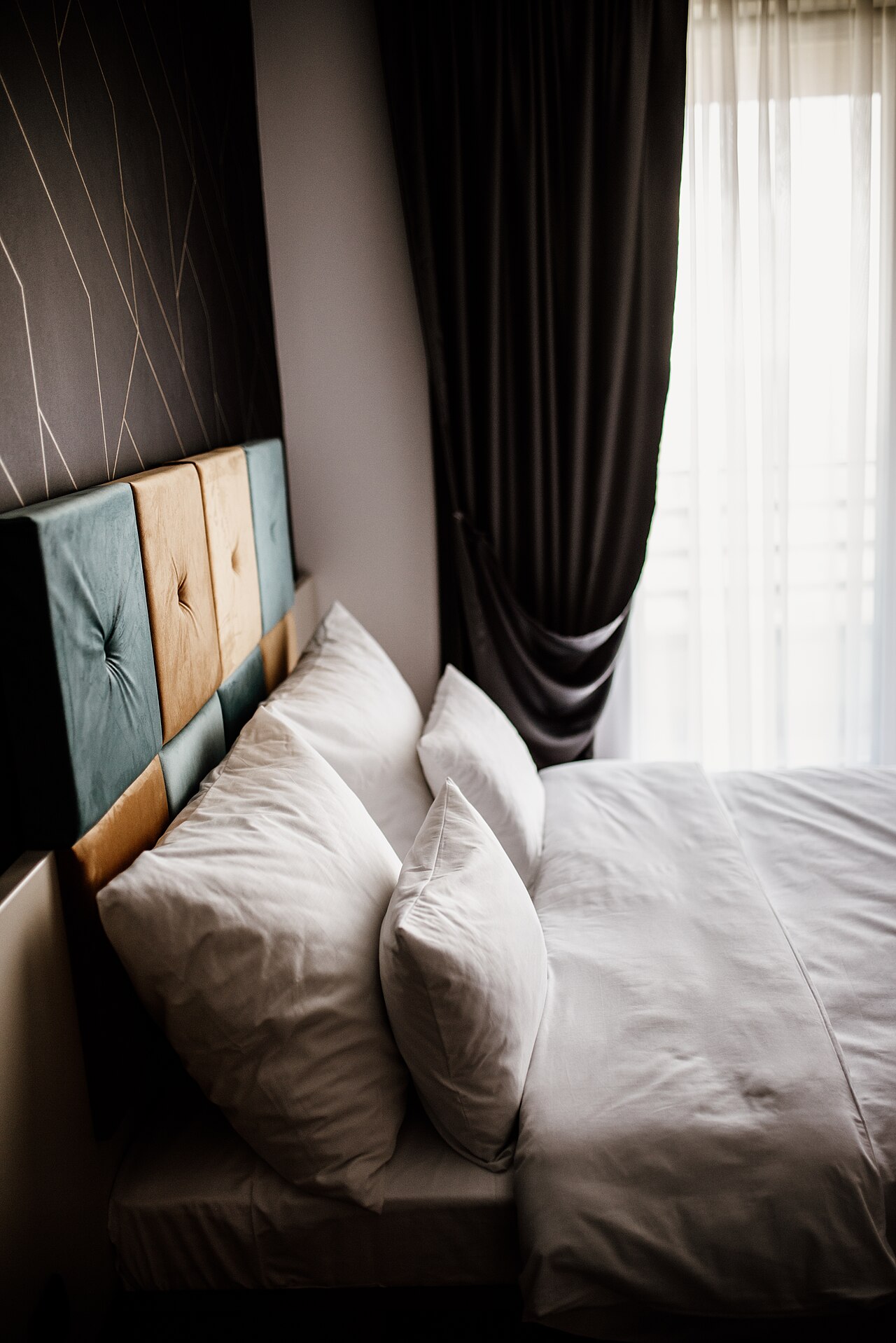 Panelled headboard with sheer curtains and soft daylight