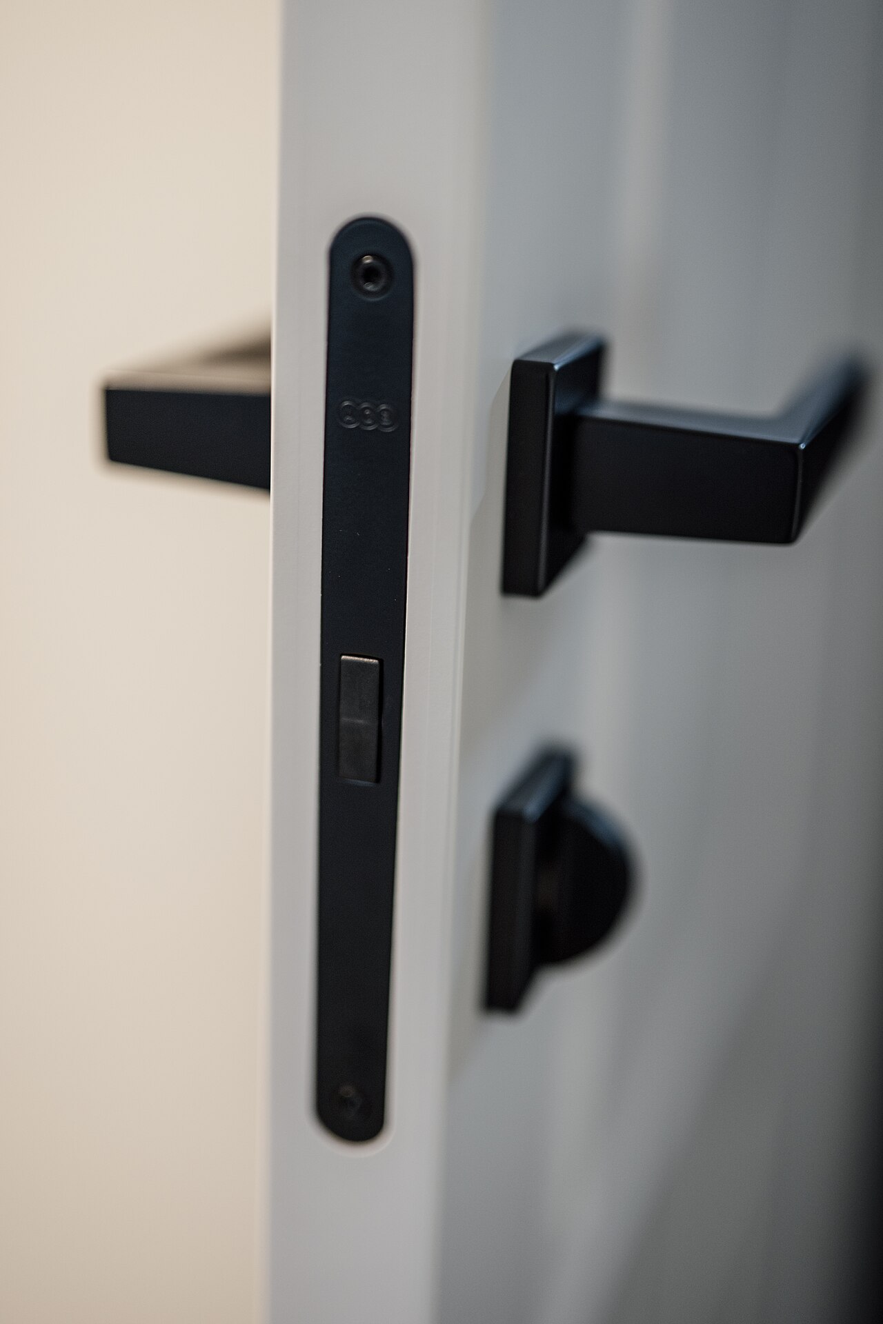 Close-up of a matte black door lever handle and lock plate
