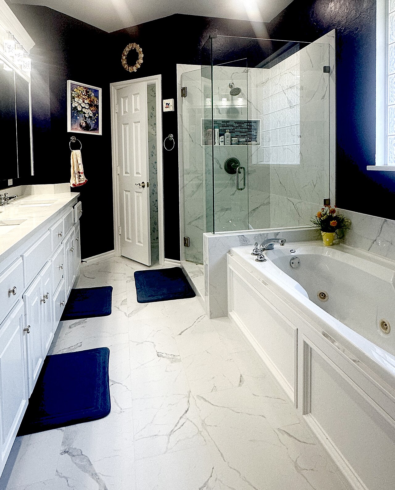 Modern bathroom with glass-enclosed shower and marble tile walls
